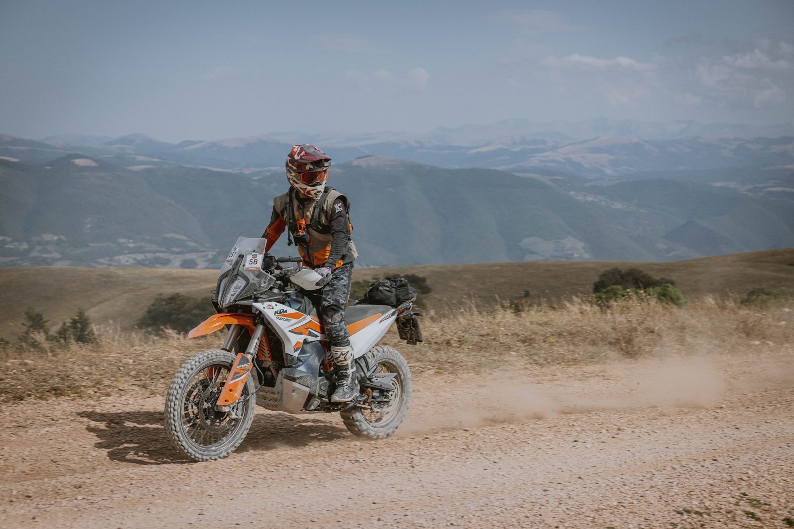 KTM rider on a dusty hilltop track with views over Umbria