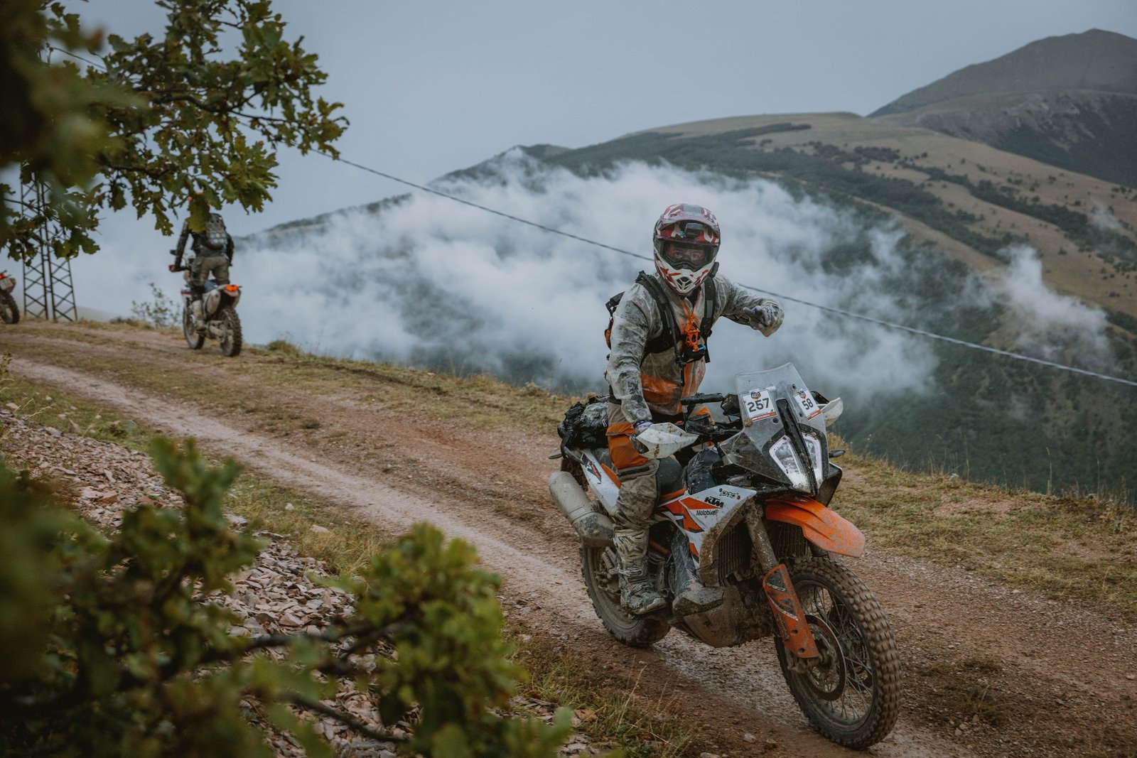 KTM rider on a mountain trail with clouds on the Apennine peaks