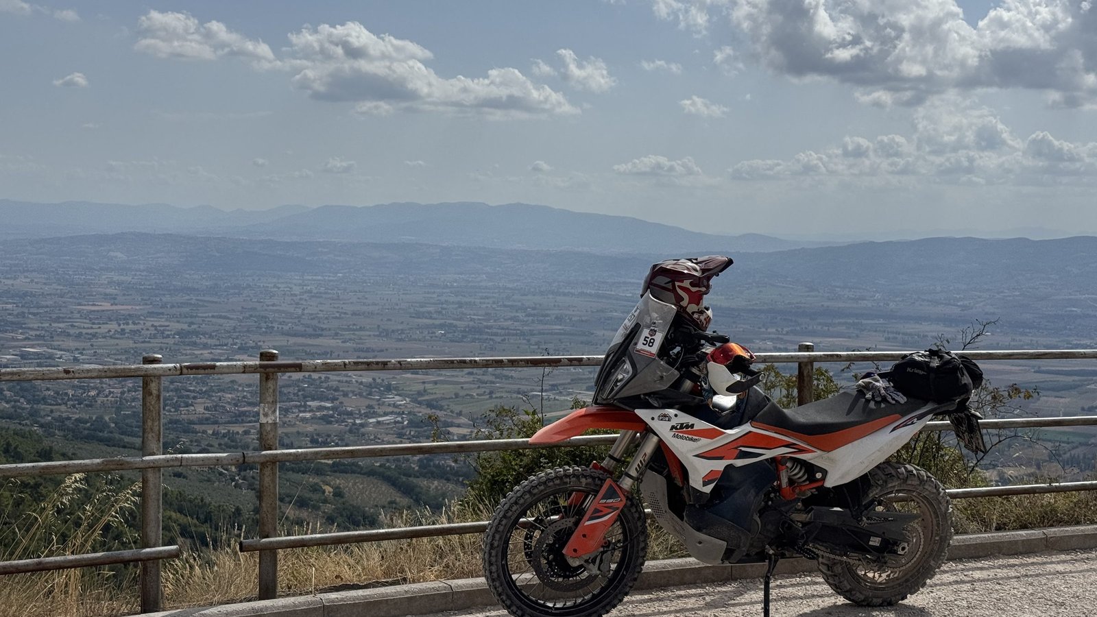 KTM adventure bike at a viewpoint over an Umbrian valley