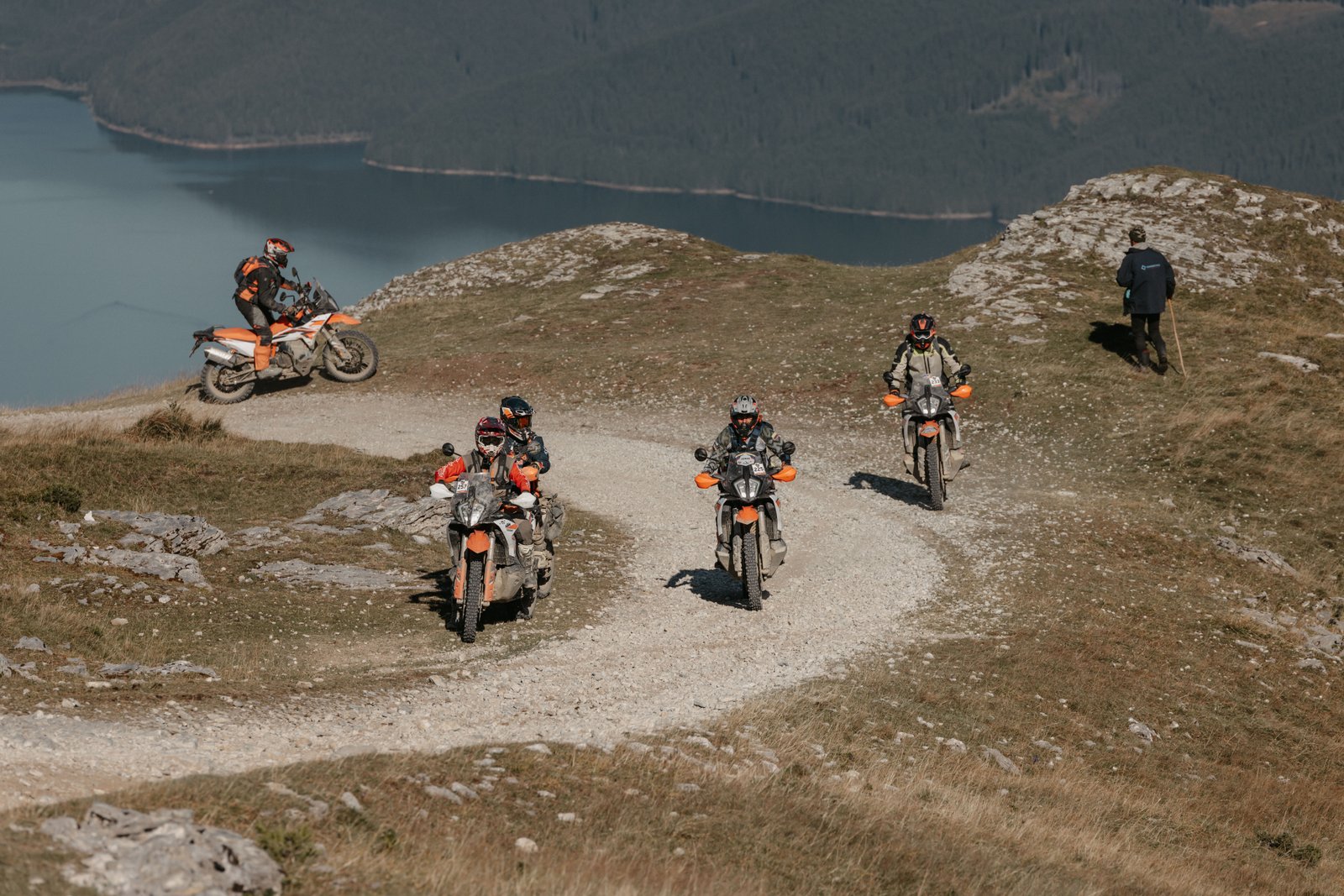 Group of riders on a mountain switchback with a lake below