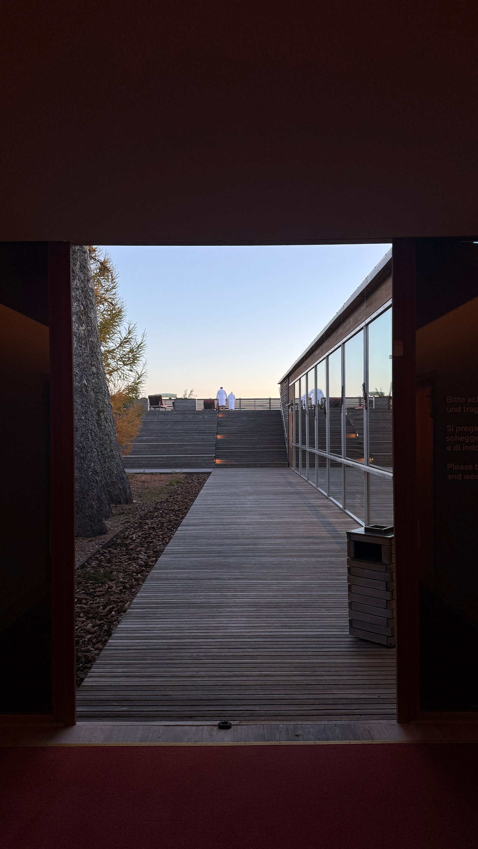 Vigilius Mountain Resort spa outdoor terrace with robed guests on stepped wooden deck