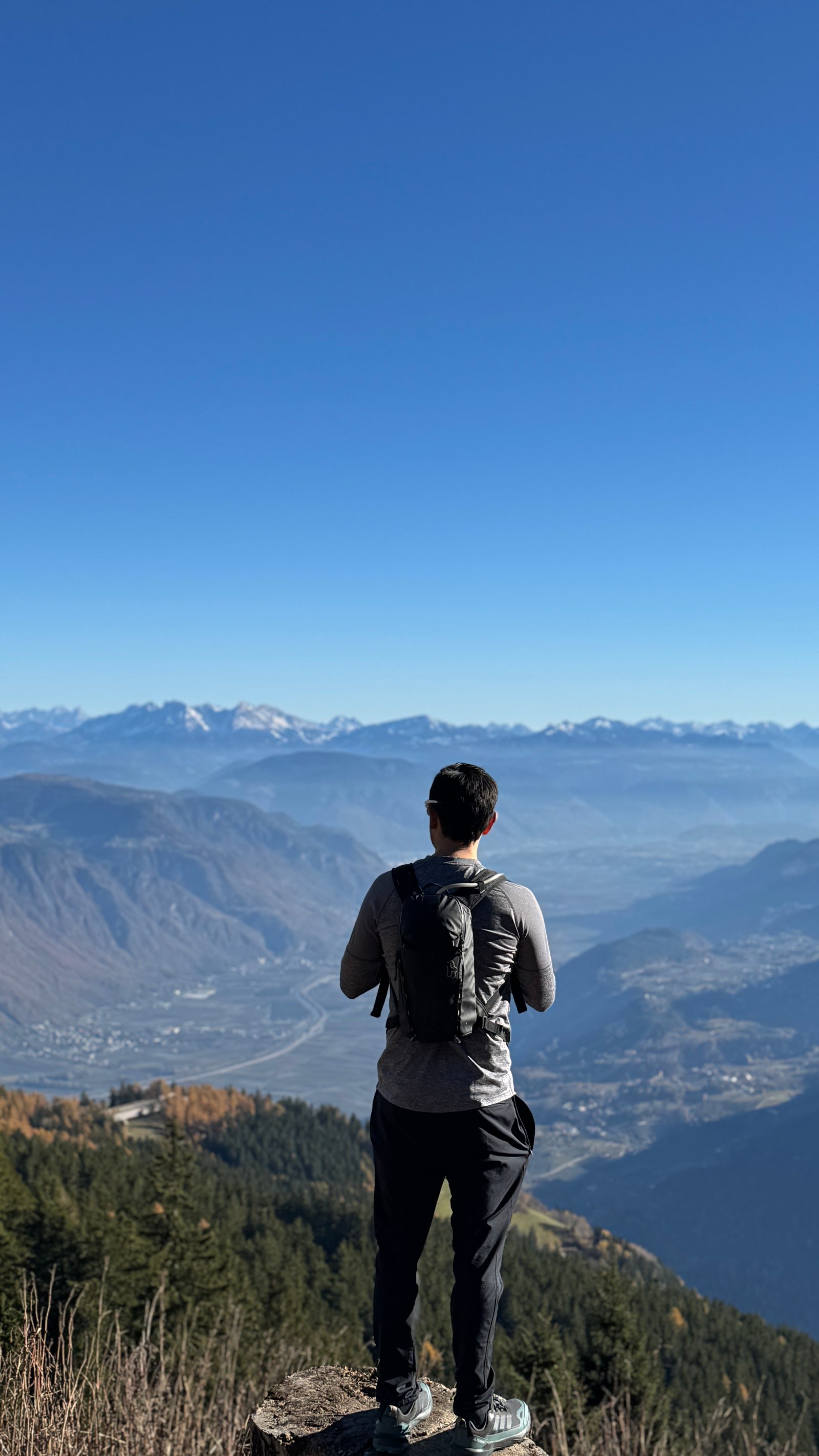 Hiking on Vigiljoch plateau with valley panorama and Salewa backpack, South Tyrol